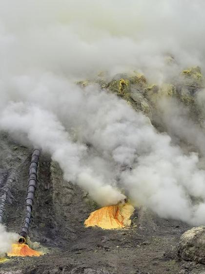Sulfur mine pipes with steam and yellow deposits