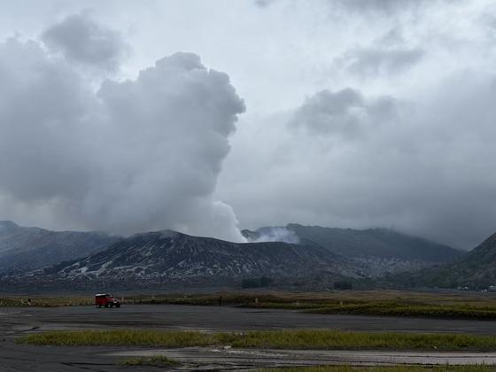 Volcanic ash column rising over a plain